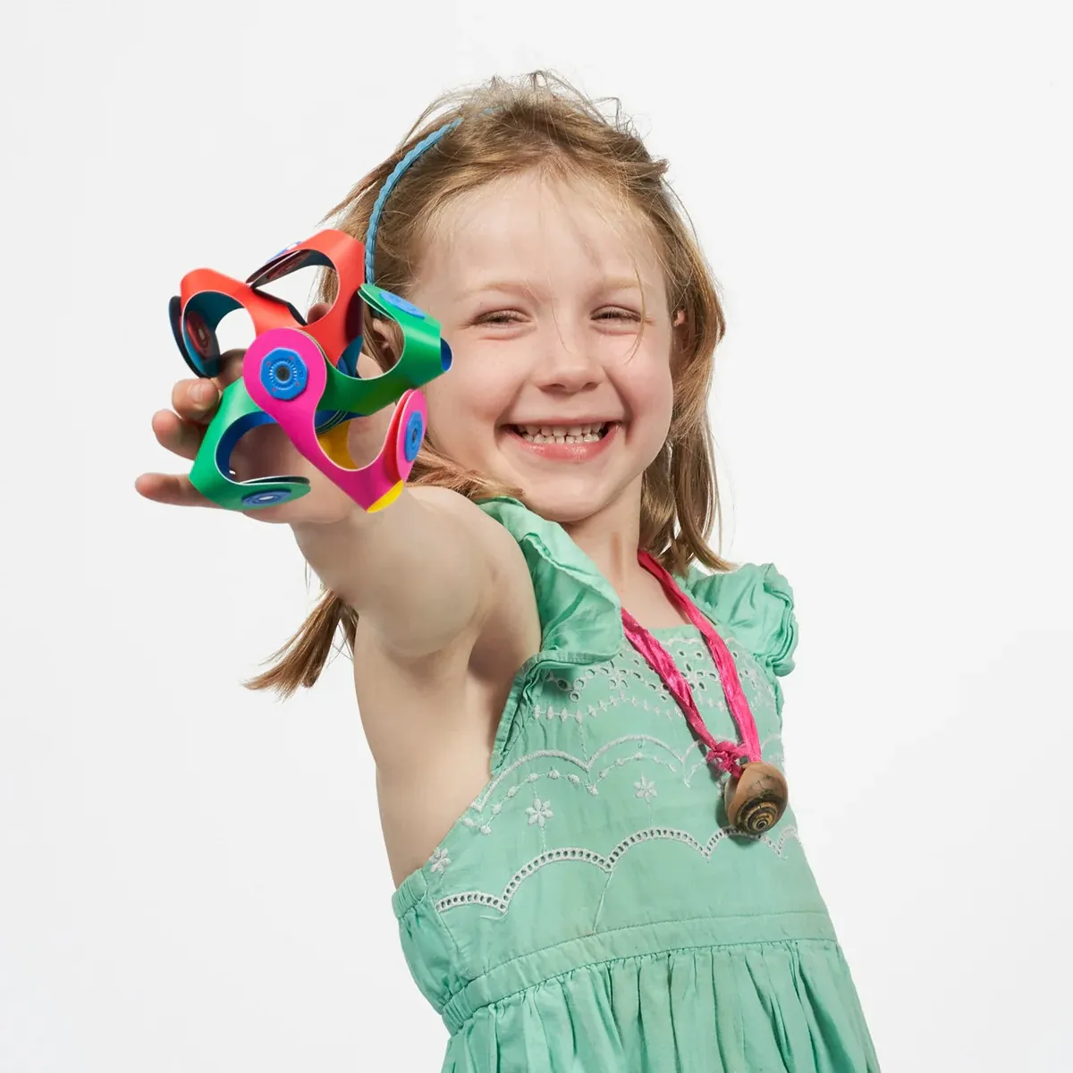 A smiling girl holding up a Tiny & Mighty build
